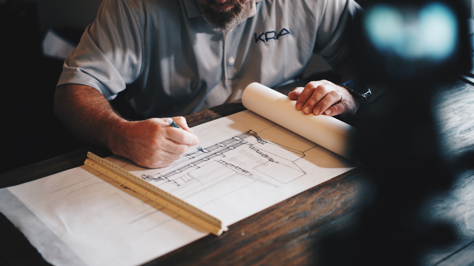 Architectural blueprints and drawing tools laid out on a desk