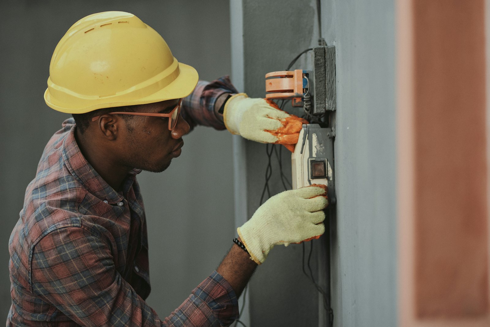 Electrician fitting cables and switchgear during a building fit-out